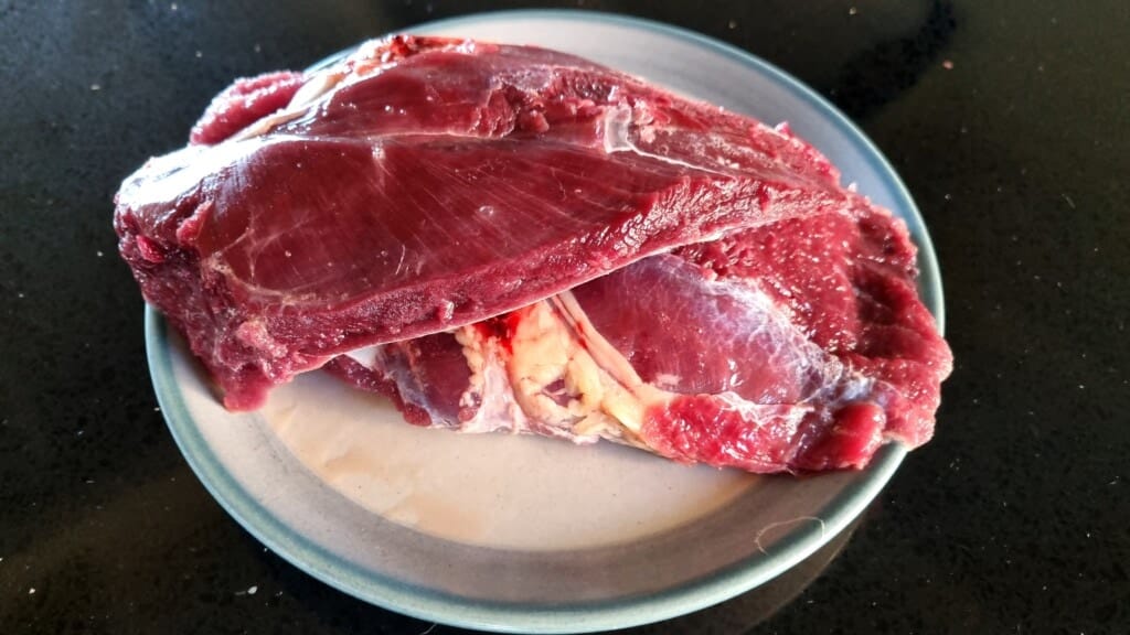 Two slices of red duck breast on a plate