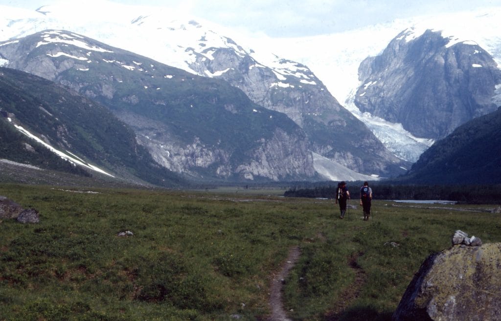 Picture of a grassy valley with snowy steep mountains either side